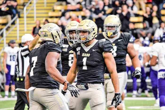Christian Elliss celebrates with teammates during an Idaho football game